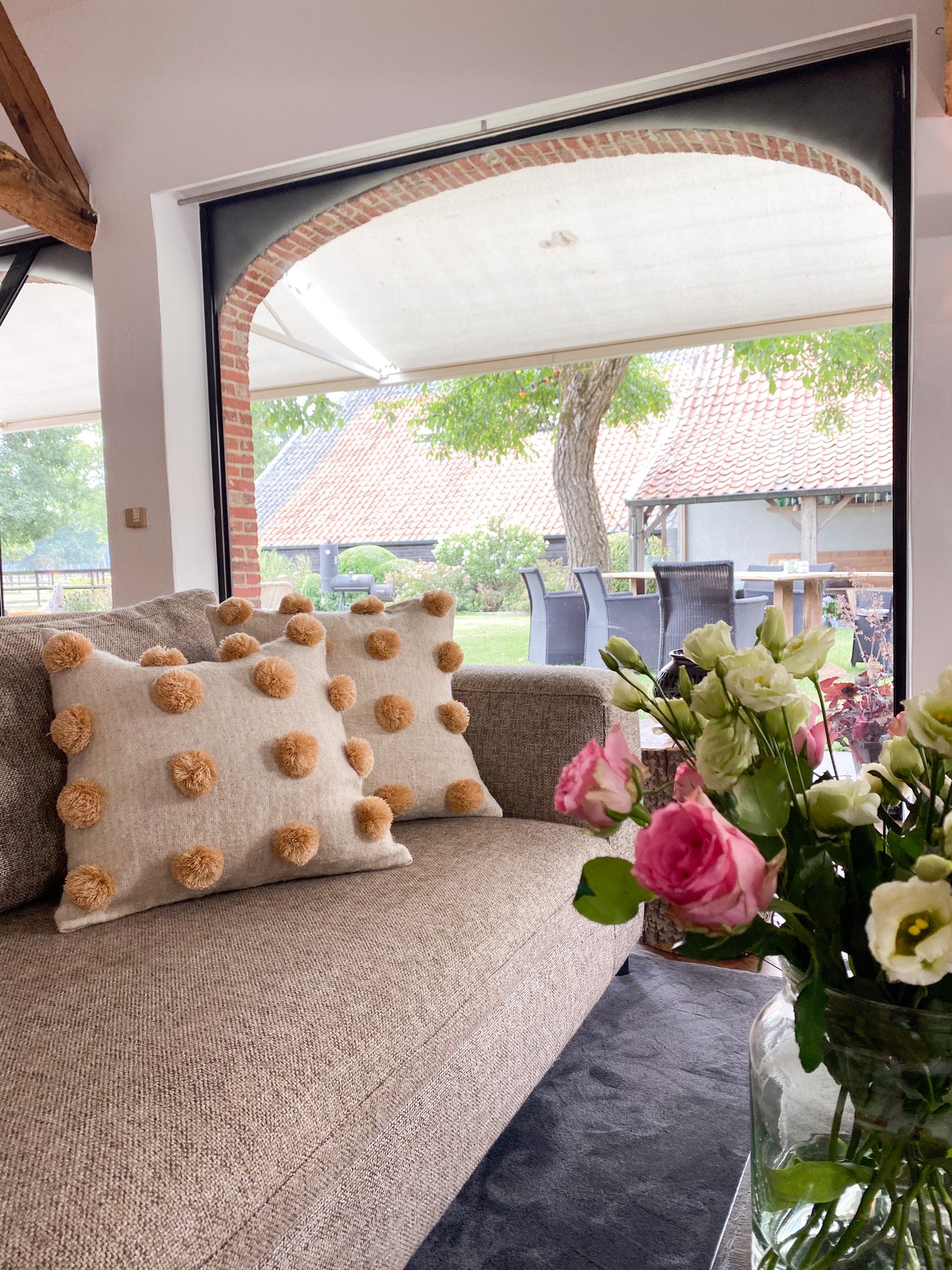 Stylish Beige Wool Cushion with Delightful Pom Poms, Elevating Living Room Decor