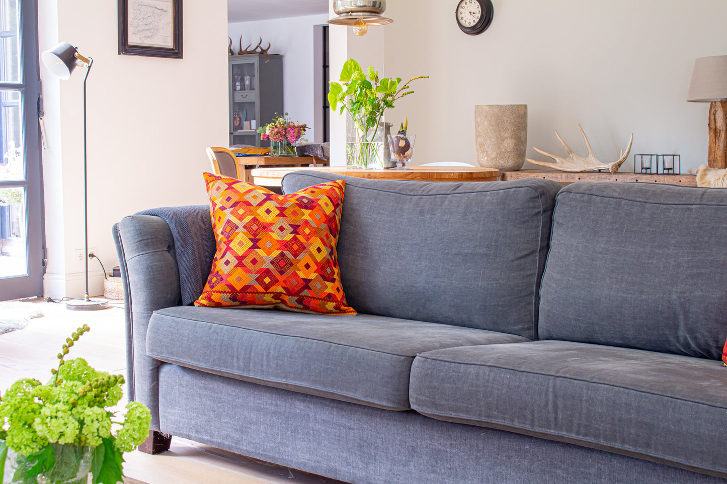 Orange Chiapas cushion with intricate diamond shapes in vibrant colors, elevating living room decor.