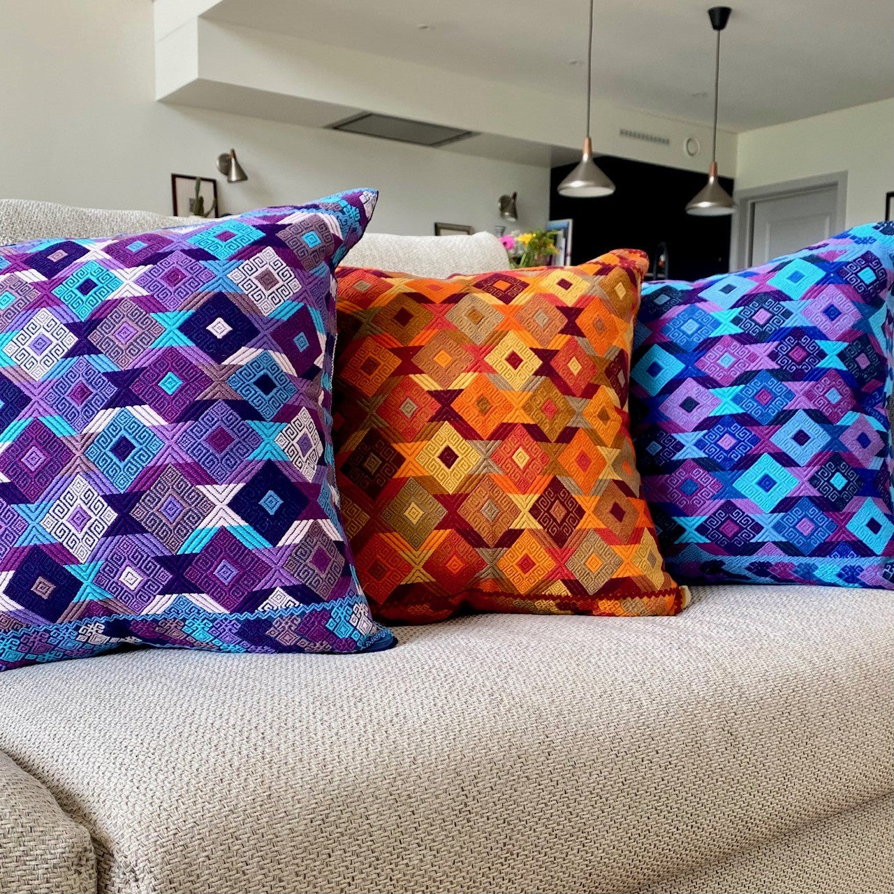 Juanas Chiapas Cushions Collection with intricate diamond shapes in vibrant colors, elevating living room decor.