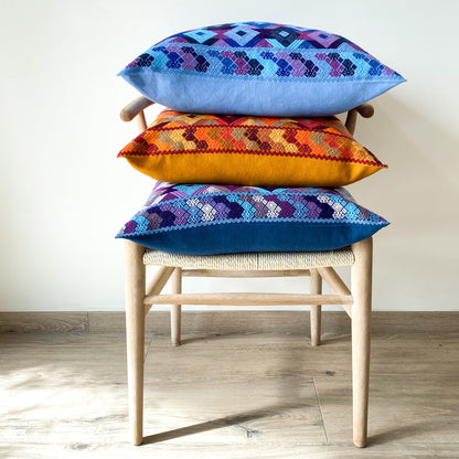 Juanas Chiapas Cushions Collection with intricate diamond shapes in vibrant colors, on a chair.