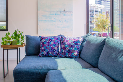 Purple shades Chiapas cushion with intricate diamond shapes in vibrant colors, elevating living room decor.