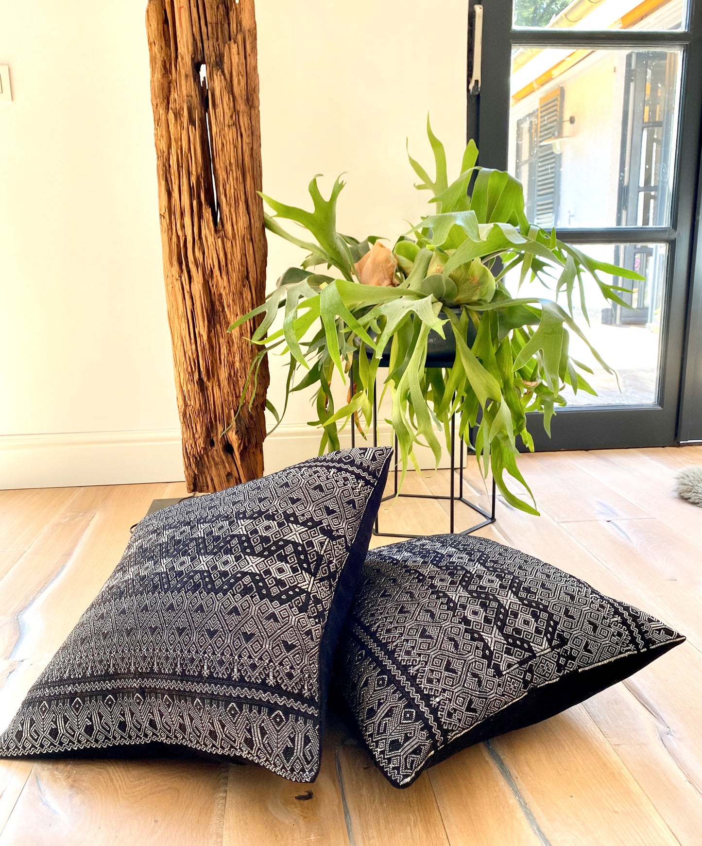 Silver metallic thread Diamond Brocade Chiapas Cushion, featuring a black cotton base, decorating a corner