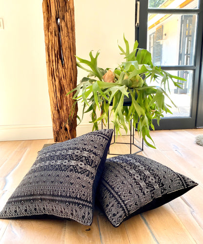 Silver metallic thread Diamond Brocade Chiapas Cushion, featuring a black cotton base, decorating a corner