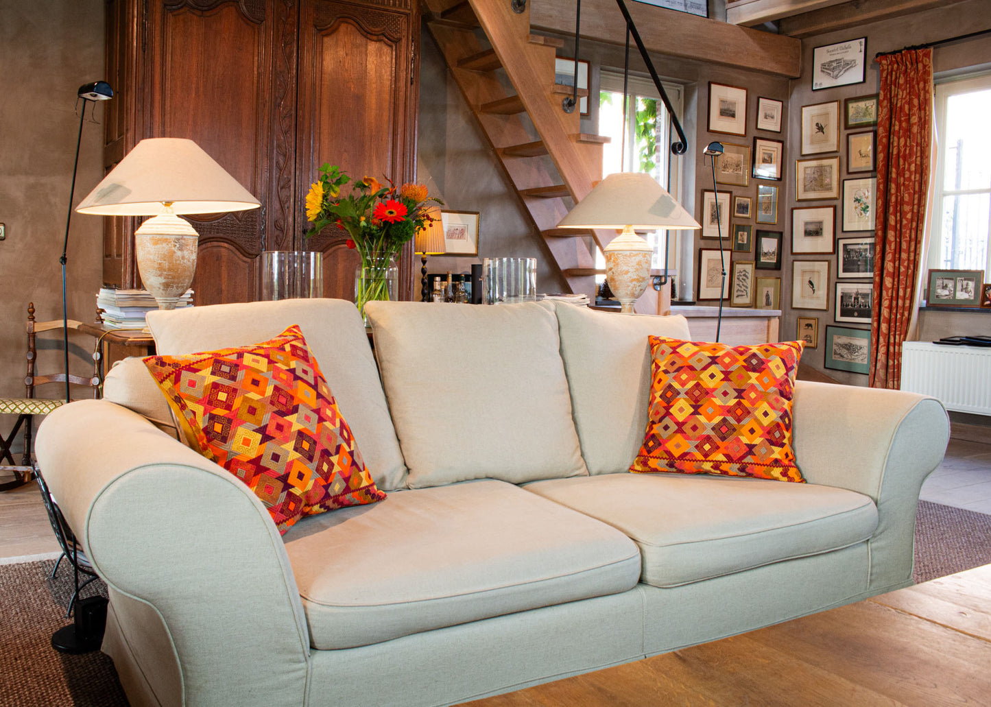 Orange Chiapas cushion with intricate diamond shapes in vibrant colors, elevating living room decor.