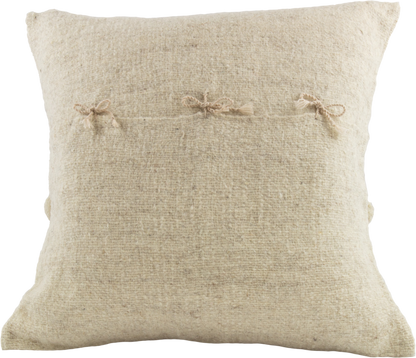 Beige Cushion crafted from 100% wool, adorned with charming beige pom poms and featuring a secure folding back with cute delicate ribbons closure.